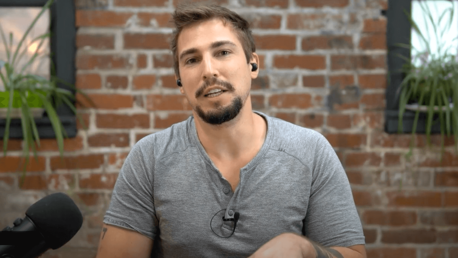 there is a man sitting in front of a microphone with a microphone in his hand