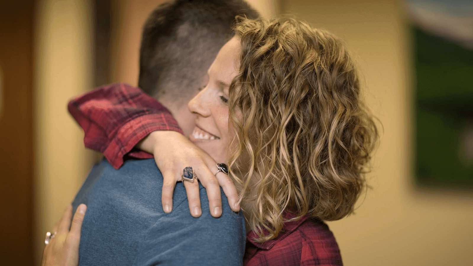 Two people hugging in therapy.