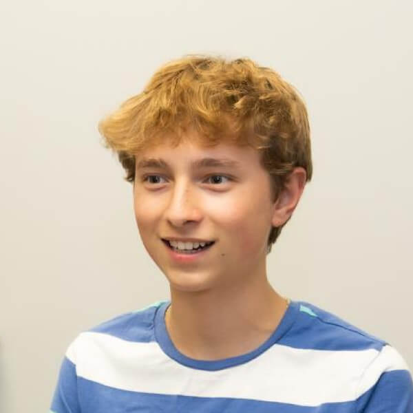 there is a young boy smiling and holding a wii controller