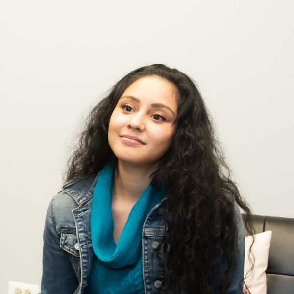 there is a woman sitting on a bed with a remote control