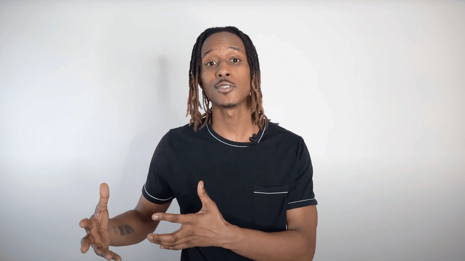 arafed man with dreadlocks making a gesture with his hands