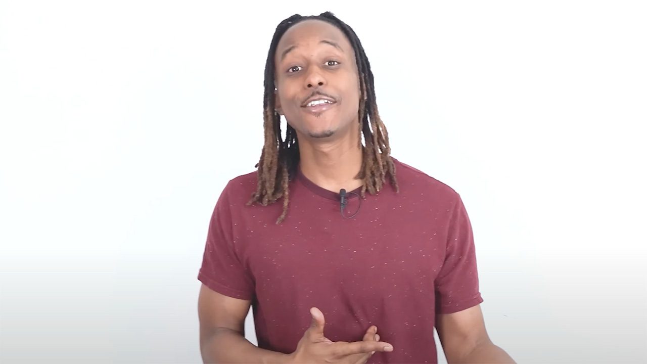 a man with dreadlocks standing in front of a white background
