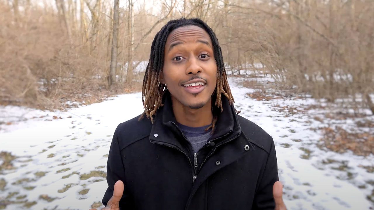 there is a man with dreadlocks standing in the snow