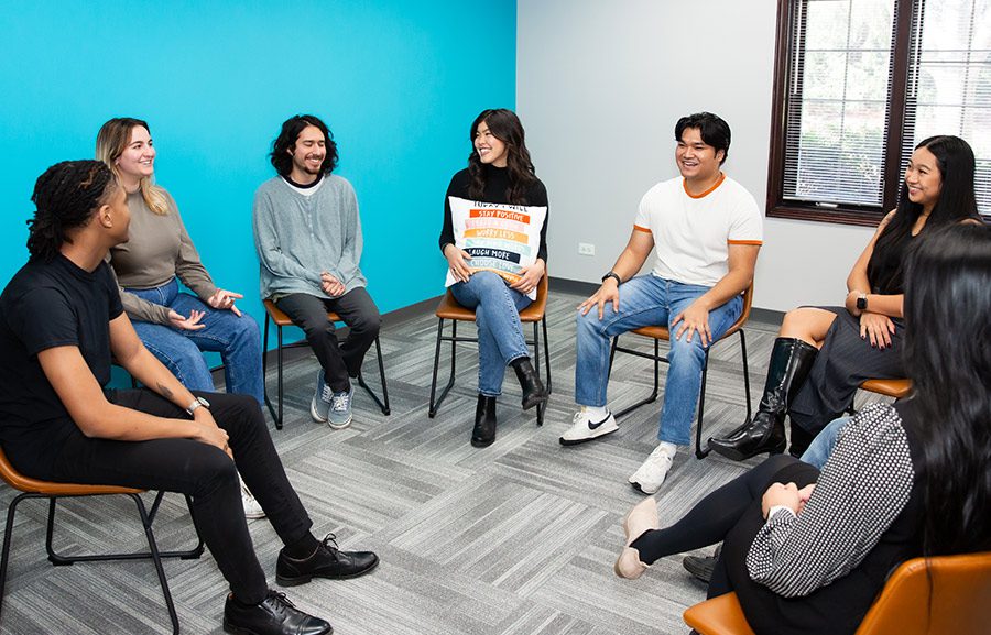 Group of young adults sitting in a circle in group therapy.