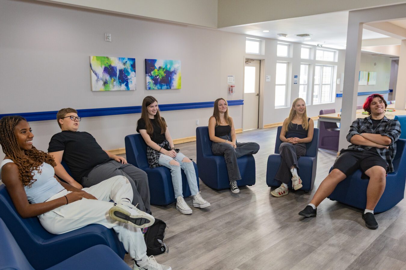 Group of boys and girls sitting in a half circle for group therapy